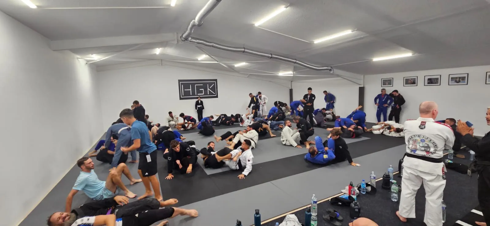 Entraînement dans le dojo de l’HGK, pratiquants en kimono et en rashguard au sol